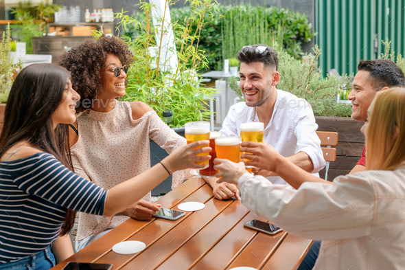 Group of friends celebrating at an open air restaurant - Stock Photo - Images