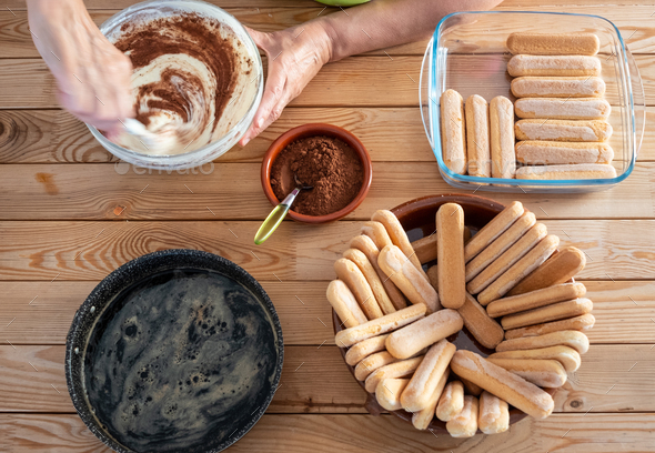 One people busy preparing a sweet tiramisu. All ingredients in the wooden table. - Stock Photo - Images