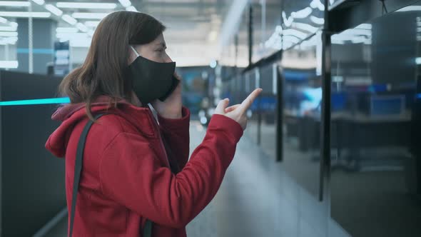 Girl in Mask Against Virus Chooses Large  TV in Store