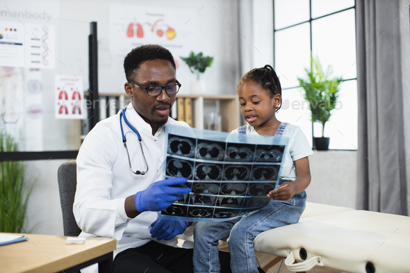 African doctor explaining results x ray scan to little girl