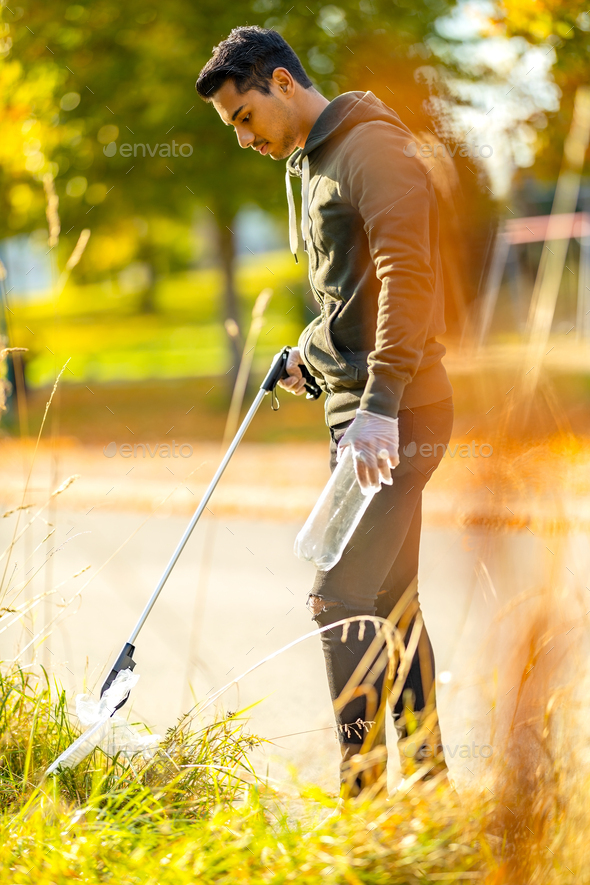 Focused volunteer conserving environment from pollution and plastic - Stock Photo - Images