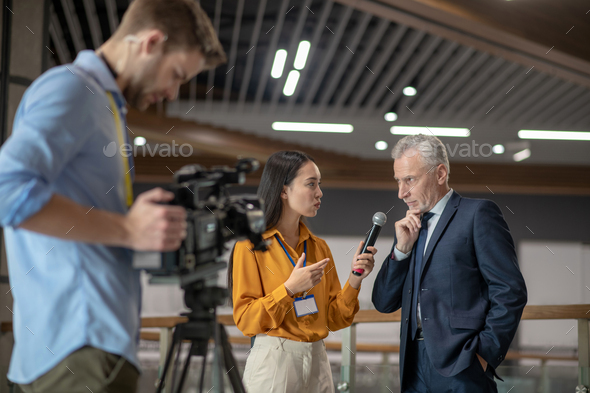 Young female reporter having interview with famous businessman