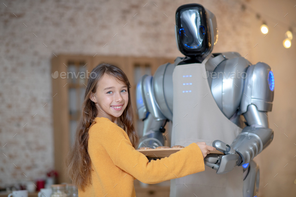 Cute girl and house robot cooking dinner together