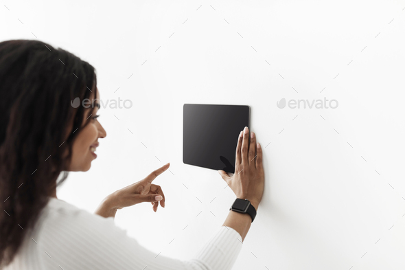 African american woman using digital tablet with blank black screen with smart home control system