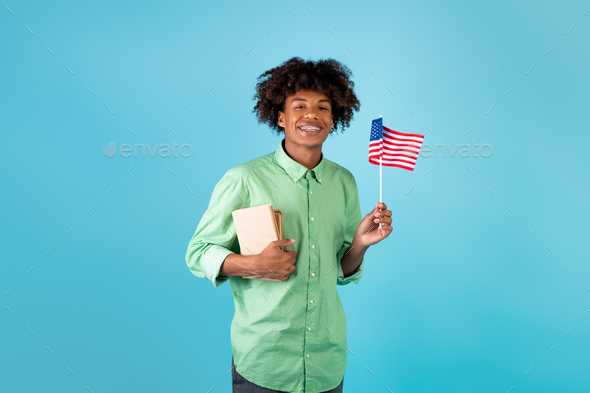 Student exchange and learning english. Zoomer happy black guy with books and small flag of USA, blue