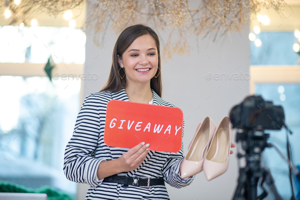 Positive young blogger promoting her giveaway for shoes