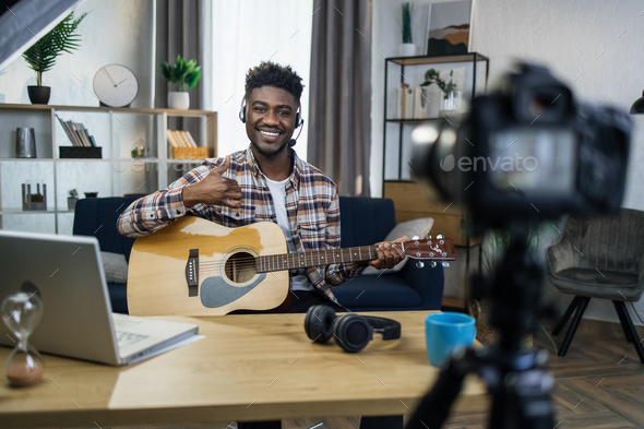 African guitarist using camera for making online stream