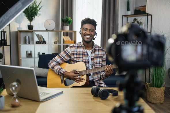 African man recording video tutorial how to play guitar