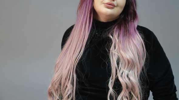 European woman talking to the camera on a gray background alt