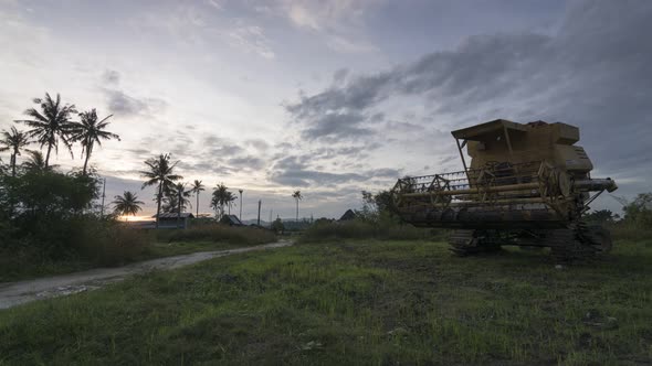Timelapse harvester rest besides coconut trees. alt