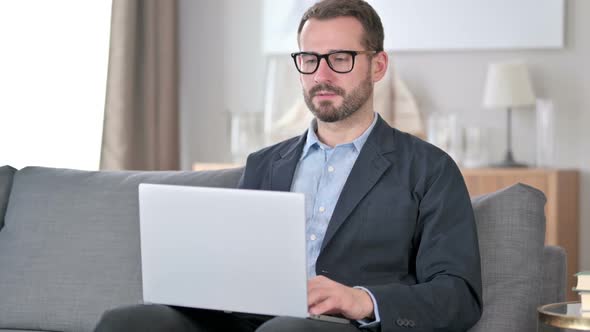 Young Businessman Doing Video Call on Laptop at Home alt