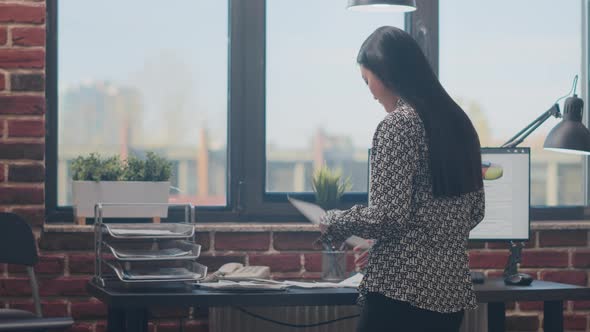 Close Up of Employee Working with Documents and Computer alt
