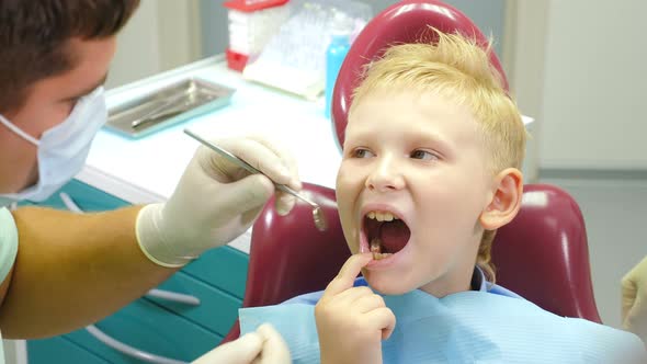Dental Health Concept. Male Dentist Treating Little Boy in Dental Clinic. Pediatric Dentistry alt