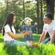 Happy Parents with Toddler Daughter Together on Green Grass in City Park - VideoHive Item for Sale
