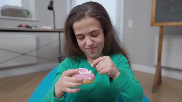 Happy Little Person Tasting Sweet Delicious Pink Donut Looking at Camera with Satisfied Facial alt