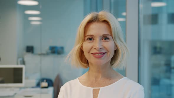 Portrait of Elegant Mature Businesswoman Smiling in Office Looking at Camera alt