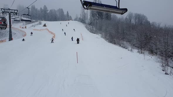 People skiing on the snowy slope of Bukovel ski resort in the Ukrainian Carpathian mountains.