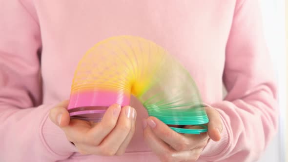 Plastic rainbow toy in hands. Colored spiral for games and tricks popular in the 90s.