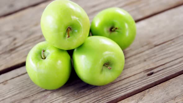 Green apples arranged on wooden plank alt