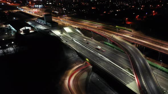 Drone shot of night traffic on a motorway showing cars and lanes of light with Tunnel and viaducts o alt