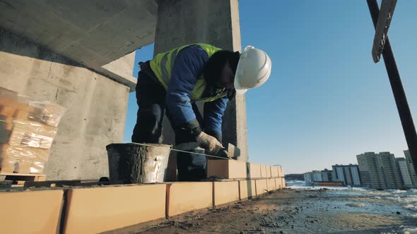 Brick Wall Is Getting Constructed By an Industrial Worker alt