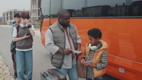 Passengers with Tickets Standing Near Bus Before Ride alt