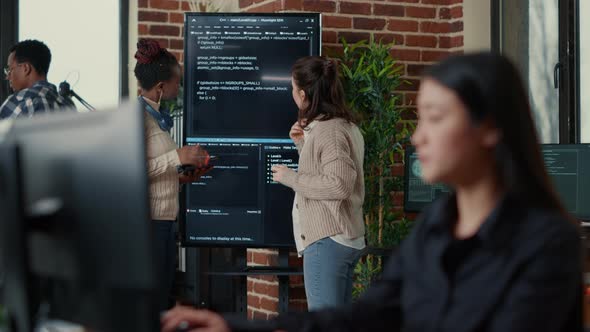 System Engineers Comparing Source Code on Wall Screen Tv Analyzing Errors Using Digital Tablet alt