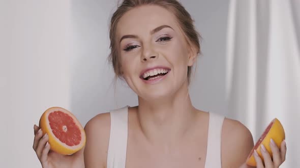 Girl Hiding Her Face with Pieces of Fruit Lauging and Being Surprised alt