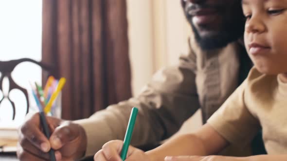 Biracial little boy scribbling on paper and grimacing