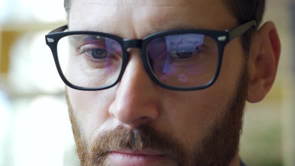 Businessman Trader Eyes in Glasses with Finance Chart and Graph Reflection