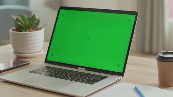 Laptop With Green Mock-Up Screen On The Table alt