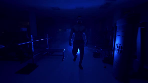 Man preparing for training. Handsome athletic sportsman preparing for training in dark gym alt