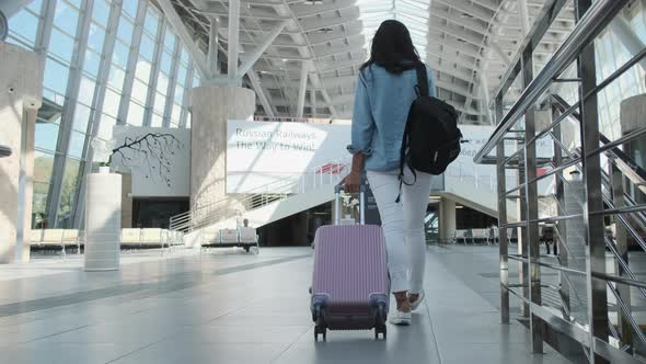 Passengers in Big Modern Railway Terminal Woman Is Rolling Suitcase alt