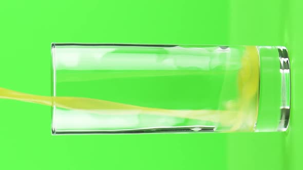 Vertical Video Juice Pouring Into Glass Isolated on Light Green Background