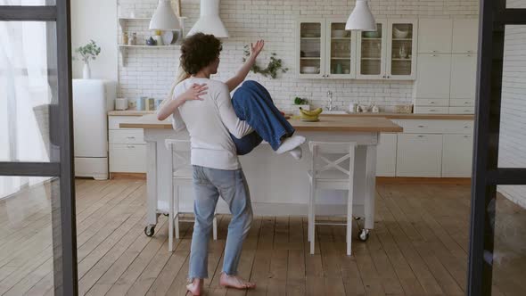 Happy Couple Spinning Around in New House alt