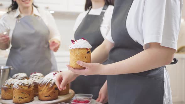 a Happy Women Decorate Icing Dried Berries and Flowers Easter Cakes alt