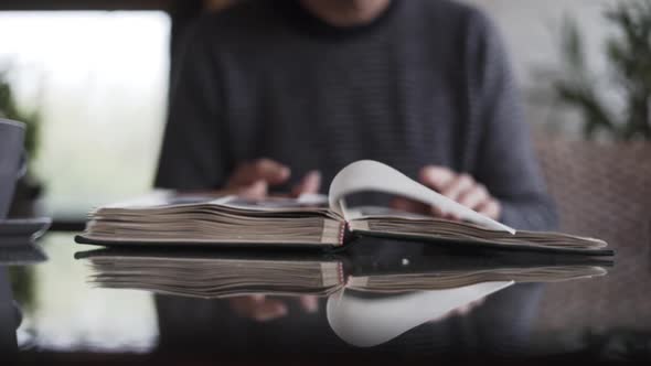 Man Turning Pages Of Photo Album alt