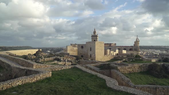 Cittadella Fortress Ruins and Houses Filled with Greenery on a Sunny Golden Hour Evening alt