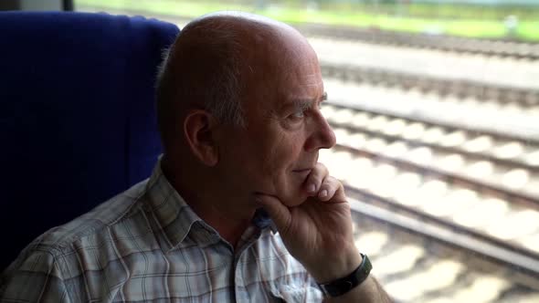 Elderly Passenger of Suburban Train, Man Is Looking at Window, Travelling Alone, Trip and Voyage alt