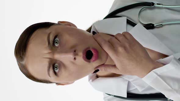 Vertical Shot Caucasian Woman Doctor is Very Surprised Opens Her Mouth Holds Chin with Hand