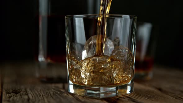 Super Slow Motion Shot of Pouring Whiskey Into Glass with Ice Cubes at 1000Fps with Camera Movement alt