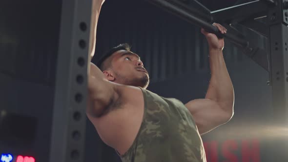 Asian active male athlete or sportsman perform bodybuilding by hand pulling up on pull up. alt