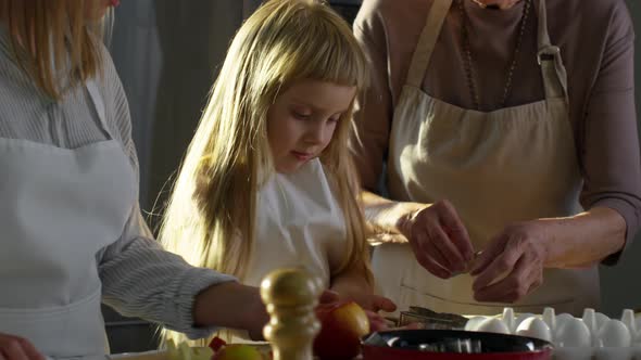 Adorable Girl Making Cookies with Grandma and Mother alt