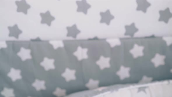 Mother Rocks Newborn Baby in Crib with Sleeping Cocoon alt