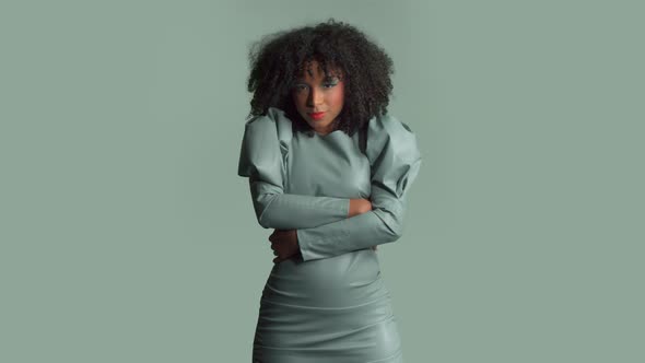 Mixed Race Woman with Big Curly Hair in Leather Fashion Dress in Studio