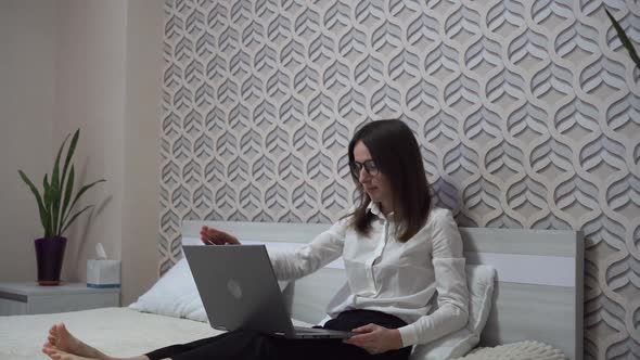 Young Woman in White Blouse Works with a Laptop in Her Bedroom Work From Home Concept Own Quarantine