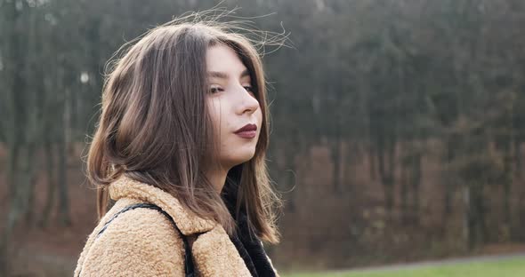 Portrait of Young Attractive Female Who Smiling and Looking at the Camera on Green Lawn. Cheerfully alt
