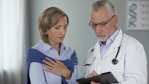 Elderly Doctor Talking to Female Patient Showing Results, Disease, Treatment Way alt