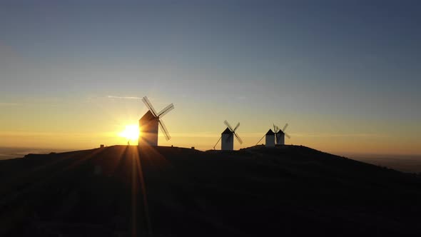 Aerial view of windmills in the countryside in Spain at sunrise alt