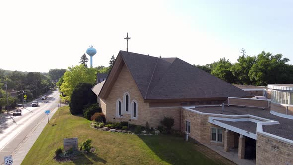 Church building in Excelsior, Minnesota, set along a busy road with blue sky and clouds.